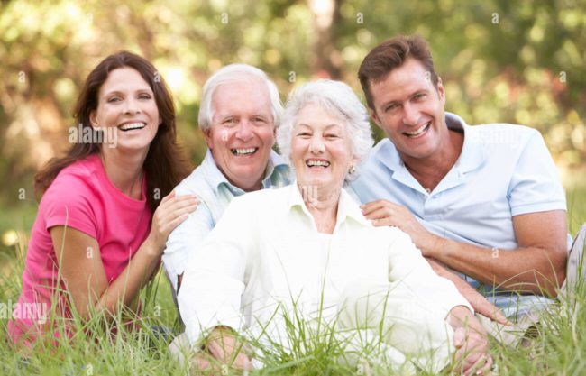 senior-couple-with-grown-up-children-in-park-BR6JK4