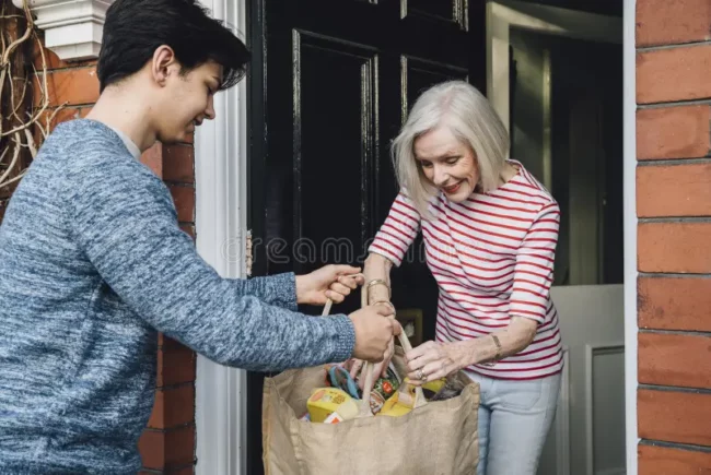 delivering-groceries-to-elderly-teenage-boy-some-woman-handing-her-shopping-bag-her-front-door-92302624