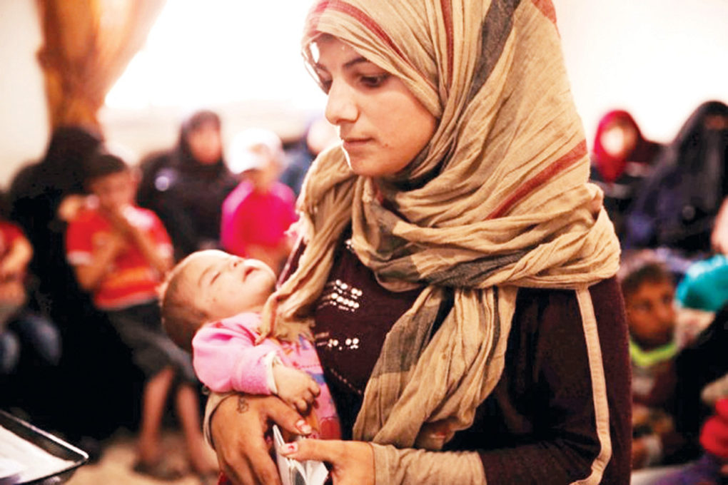 Syrian_mother_Samira_visits_a_UNHCR_community_centre_in_Aleppo_for_legal_help_registering_her_child___s_birth.