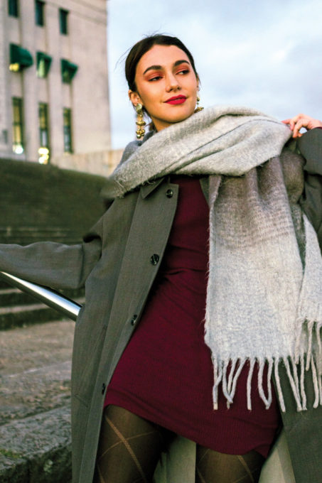 stylish-young-woman-with-woolen-scarf-around-her-near-wearing-dangling-golden-earrings